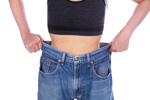 close up of woman show her weight loss and wearing her old jeans isolated on a white background