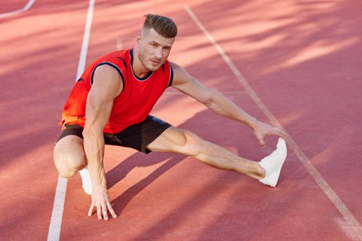 athletic man doing exercises outdoors sports field exercise. High quality photo