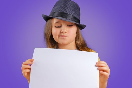 Cute little girl holds blank paper, space for text