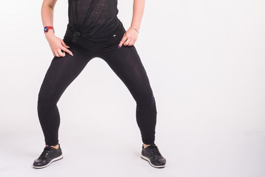 Close-up of girl dancing twerk in the dance class on white background.