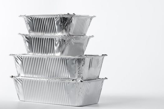 Takeaway meal in foil food box on white background close up