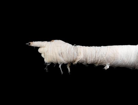 Hand of mummy indicates on dark gradient background. The horizontal position
