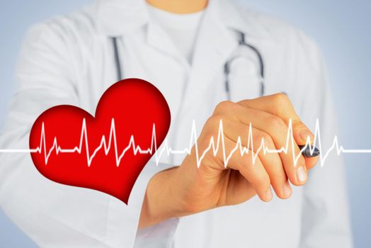 Unrecognizable man doctor is writing with pen shape of heartbeat, concept of healthcare