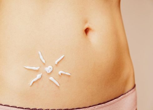 Cream in the form of sun on the skin of the abdomen, concept of skincare