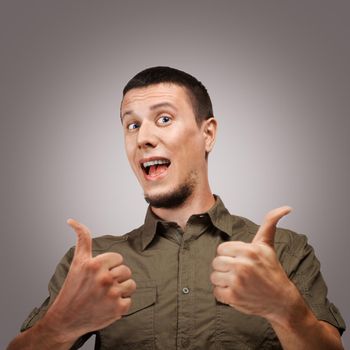 Young happy man showing thumb up sign