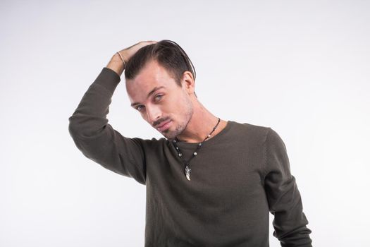 Thoughtful young handsome man against white background.