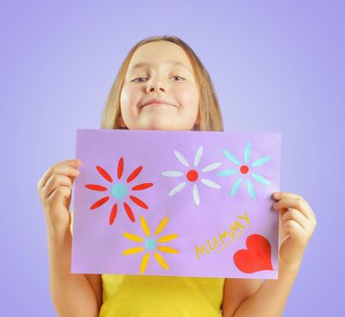 Happy little girl is showing greeting card for mothers day