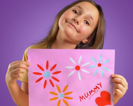 Happy little girl holds greeting card for mummy