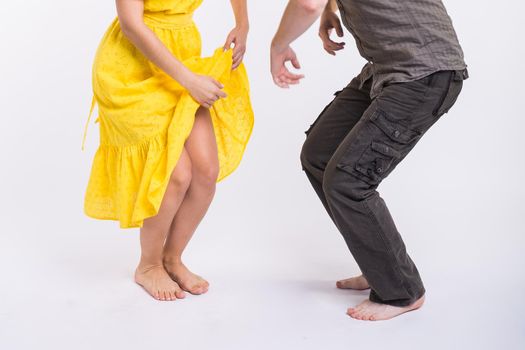 dancing latin music. Bachata, merengue, salsa and kizomba. Close-up of legs elegance pose on white room.