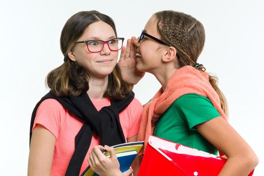 Happy high school friends are teenage girls, talk and secret. White background, with books and notebooks.