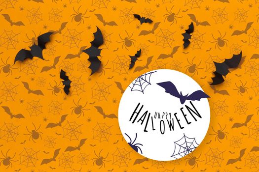 Halloween concept - black paper bats on orange background