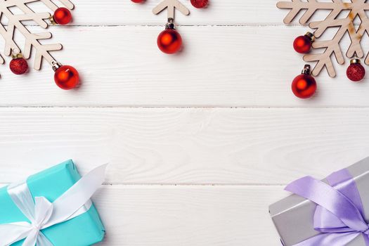 Christmas gifts and decorations on white wooden board, top view