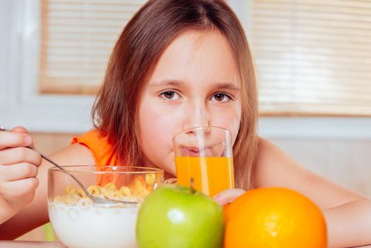 Little girl is drinking orange juice