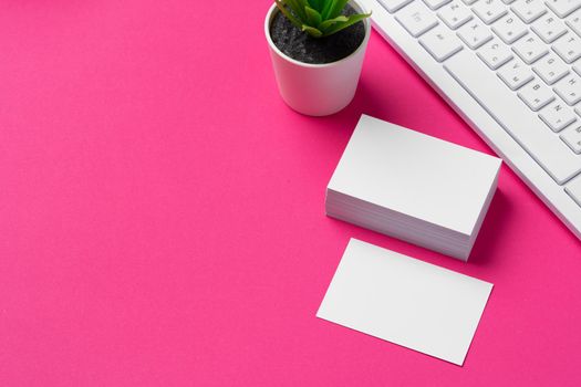 Blank business cards with supplies and keyboard on office table. Close up.