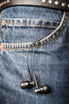 Headphones hanging off a jeans pocket