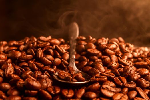 Fragrant fried coffee beans with the smoke, close-up