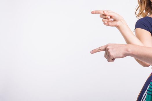 Couple pointing at the left corner with fingers standing isolated over white background. Copy space for product advertisement
