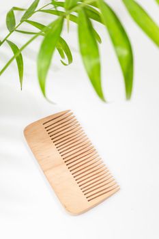 Wood comb on white background. Hairdressing tools, hair comb, eco friendly material