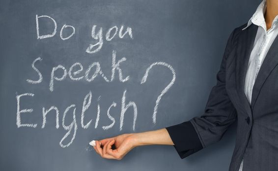 Unrecognizable teacher points to the phrase “Do you speak English?”