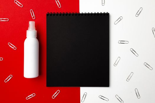 Black notepad surrounded with paper clips top view, copy space