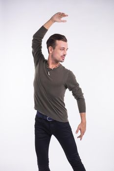 Attractive young man dancing, having fun on white background. Stylish outlook