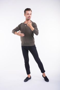 Attractive young man dancing, having fun on white background. Stylish outlook