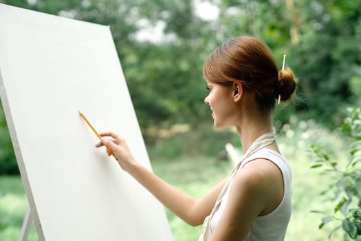 an artist in nature draws on an easel with a pencil. High quality photo