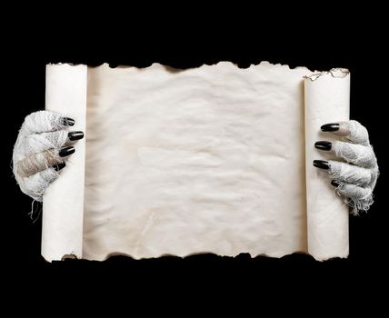 Hands of mummy holding horizontal scroll on dark background. Space for text.