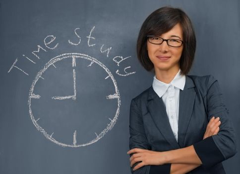 Young woman in a suit is standing near the blackboard, on which is written time study