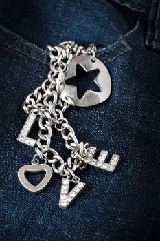 abstract the word love from woman accessory (metal chain, heart shaped and diamonds)