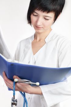 young woman doctor reads papers