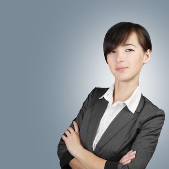 Smiling business woman in a gray suit with arms crossed