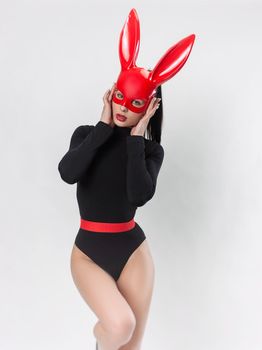 the woman in red rabbit mask and black bodysuit on white background