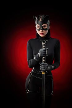 the woman in a black body belt and cat mask