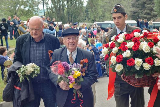 PYATIGORSK, RUSSIA - MAY 09, 2017: Carer and elderly man with a walking stick on Victory Day