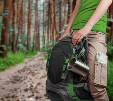 Unrecognizable woman holding a bag on the forest background