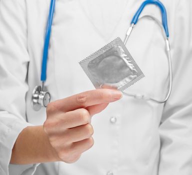 Doctor holding condom close-up. Concept safe Sex