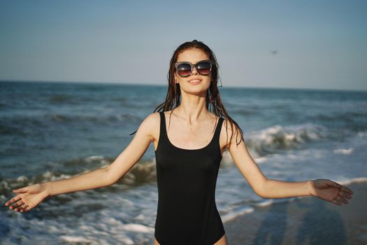 cheerful woman in black swimsuit sunglasses ocean travel. High quality photo