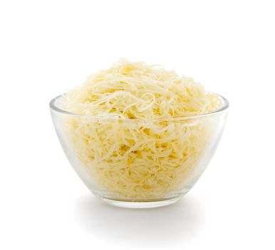 Grated cheese in a transparent plate on a white background. Side view.