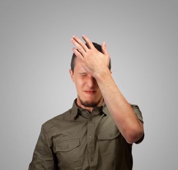 Young man strikes his forehead, concept of failure