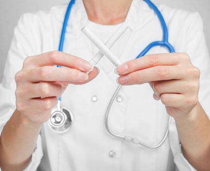 Unrecognizable doctor holding a cigarette in the shape of a cross