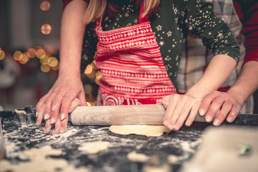 Mother and daughter rolling gingerbread dough at home