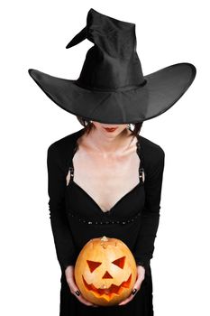 Halloween beautiful witch holding carved pumpkin on a white background