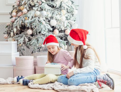 Sisters in santa hats excited of new year presents