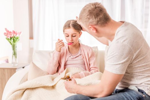 Attentive dad making sure his sick on chickenpox daughter will get better