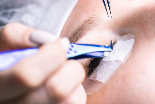 Eyelash Extension Procedure. Woman Eye with Long Eyelashes. Lashes, close up, selective focus.