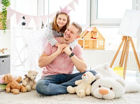 Smiling father and happy daughter spending time together in decorated room