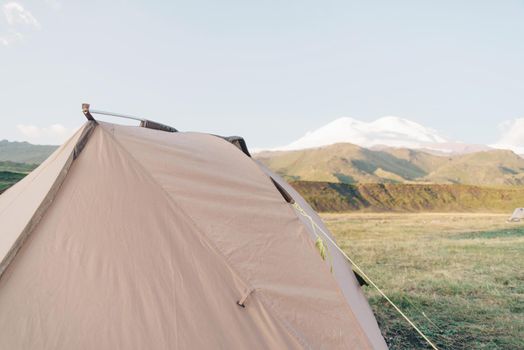 Camping hiking tent on background of Elbrus mountain in summer.