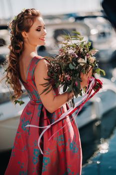 Young model girl in a beautiful dress with a bouquet of flowers on the beach in France. Girl with flowers in spring Provence on the French Riviera.