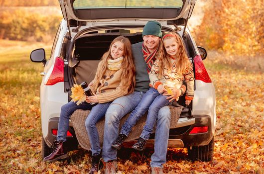 Smiling father with daughters in autumn surroundings